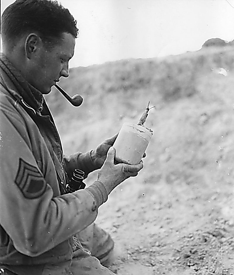 Staff Sergeant Garland Martin holds a mine left by the retreating German forces.